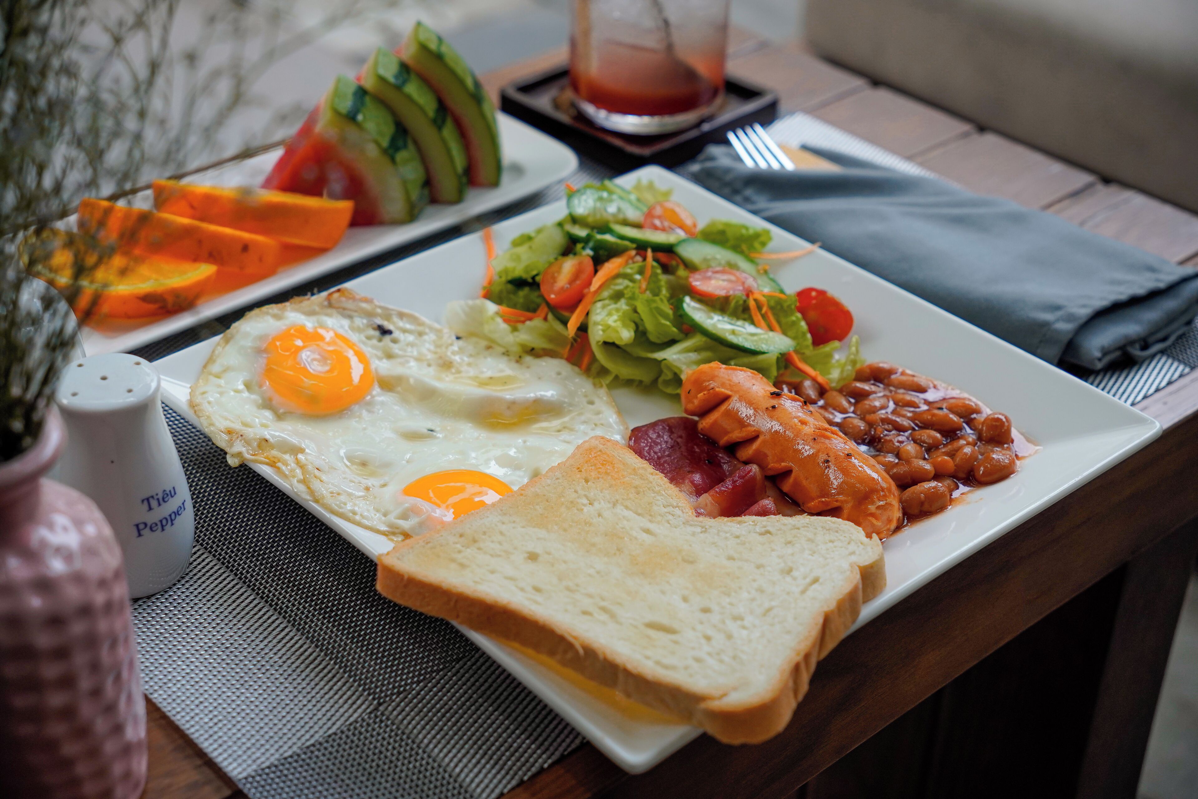 Ein Frühstücksteller mit Eiern, Toast, Bohnen und Gemüse.