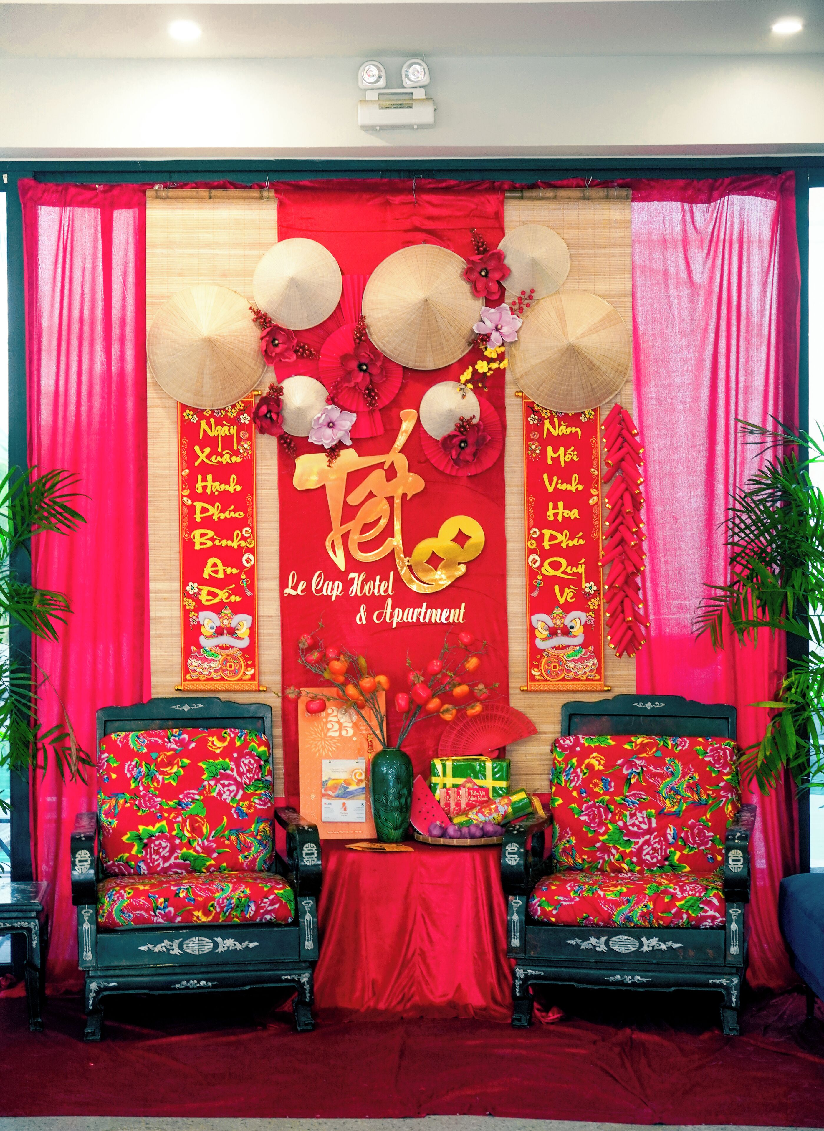 Eine traditionelle chinesische Neujahrsdekoration mit roten Verzierungen, zwei aufwendigen Stühlen und einem Tisch mit Geschenken.