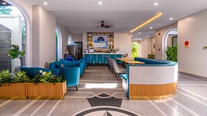 A modern interior with a bar area, seating, and potted plants. - Le Cap Hotel & Apartment (Da Nang)
