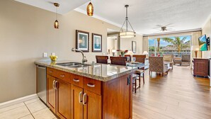 Una cocina amplia con una isla grande, armarios de madera e iluminación colgante.