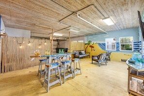 A room with a bar area, seating, and a decorative wall.