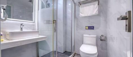 A modern bathroom with a glass-enclosed shower, a white toilet, and a sink with a mirror above it.