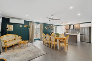 A modern kitchen with a built-in island, stainless steel appliances, and a dining area with a sofa and chairs. - Royal Romanesque holiday house in Dakabin / 3 min to shops (Dakabin)