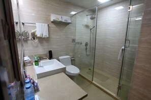 A modern bathroom with a glass-enclosed shower, a white sink, and a toilet. - Jixi International Hotel (Jixi)