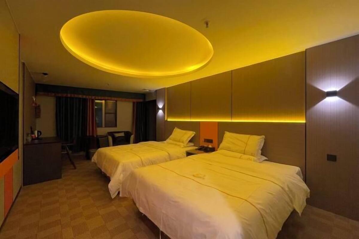 Een hotelkamer met twee bedden, een bureau en een televisie.