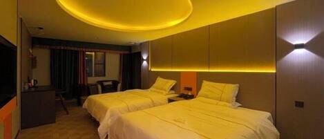 A hotel room with two beds, a desk, and a TV.
