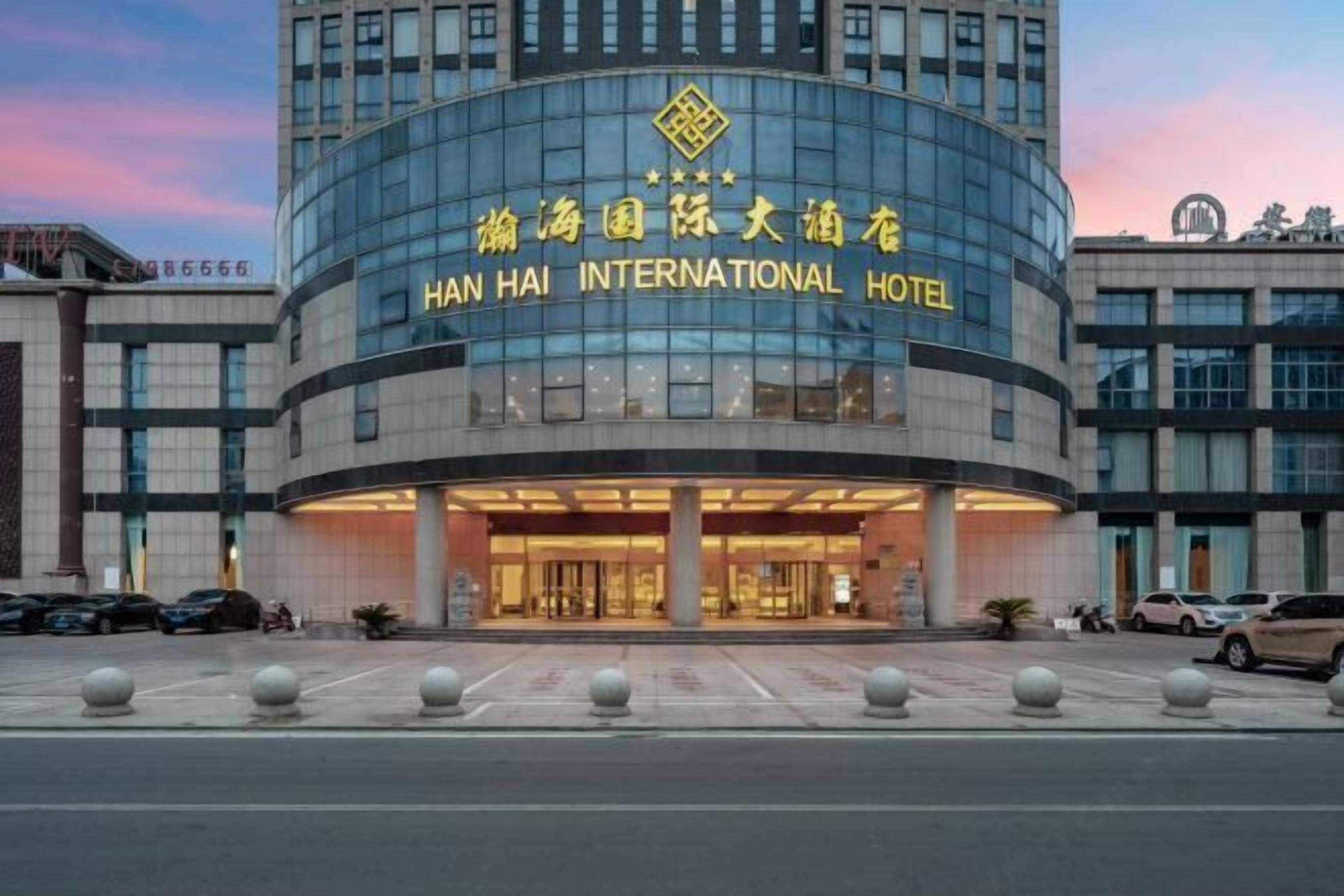 The exterior of the Han Hai International Hotel with a modern glass facade and a prominent entrance.