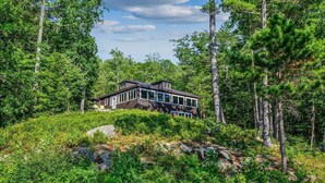 A modern house surrounded by dense forest. - Webster Lake Retreat for Nature and Water Lovers (Franklin)