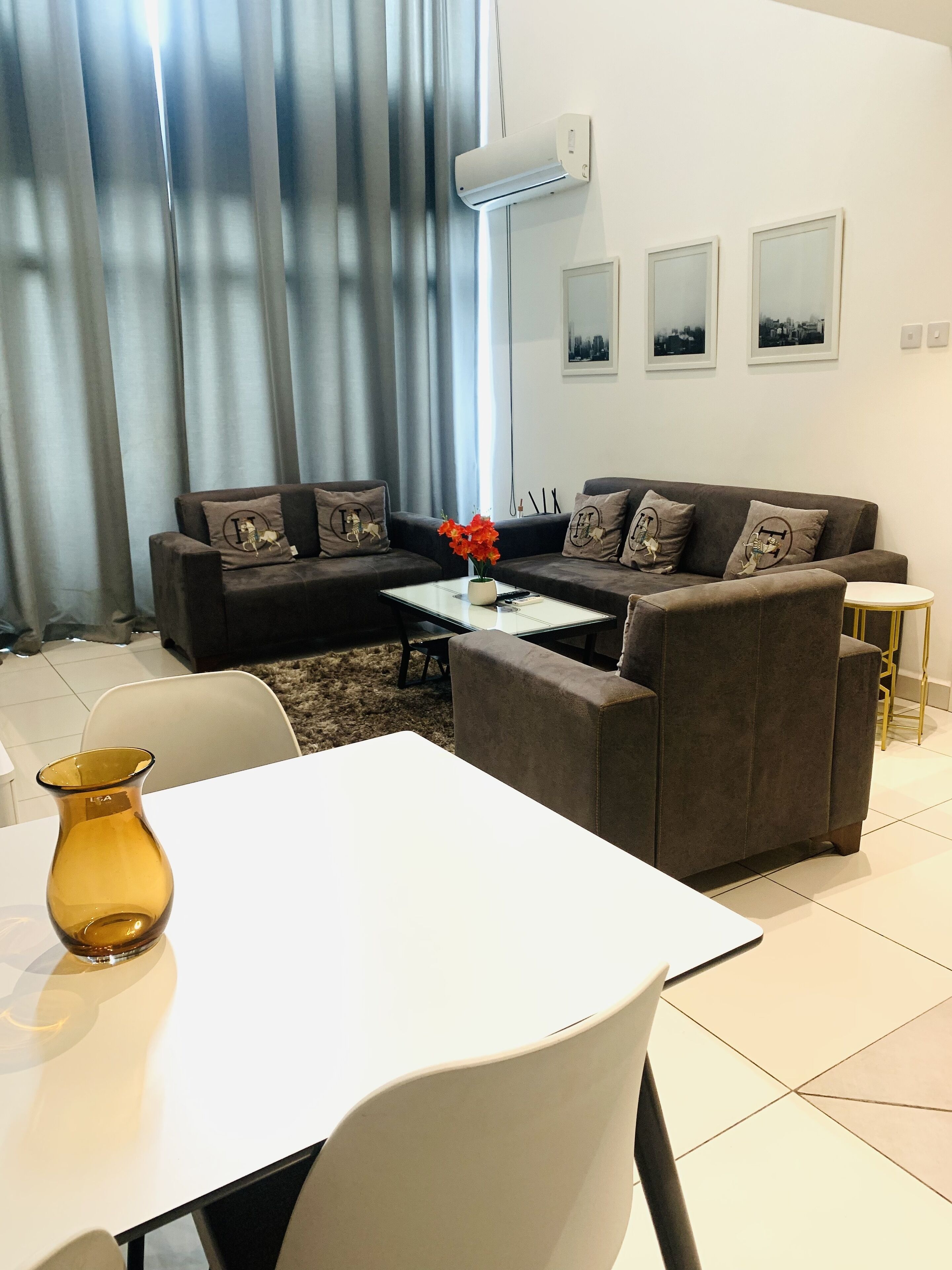 A modern living room with a sofa set, a coffee table, and a vase with flowers.