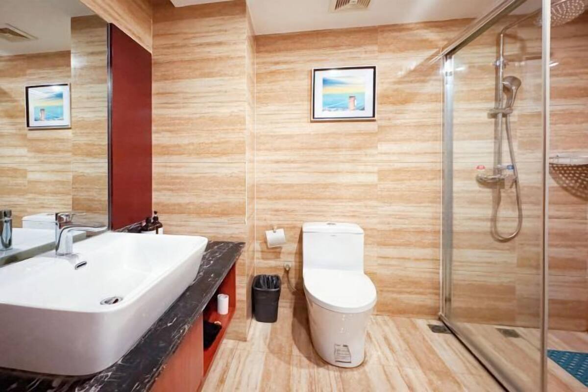 Une salle de bain moderne avec un grand lavabo, des toilettes et une douche à parois de verre.