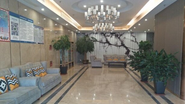 A spacious lobby with a marble floor, a chandelier, sofas with patterned cushions, and potted plants. - Pizhou Melvo Hotel (Pizhou)