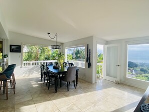 Enjoy meals in this dining area with a large table and six chairs, surrounded by lush views of the outdoors.