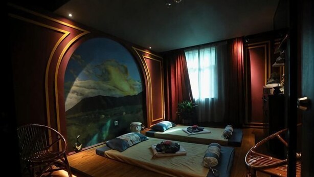 A room with a large arched window, two beds, a chair, and a small table with a tray. - Moon Palace Hotel Huizhou (Huizhou)