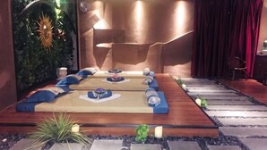 A spa room with a wooden floor, massage tables, and a red curtain backdrop. - Moon Palace Hotel Huizhou (Huizhou)