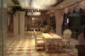 A dining area with a checkered floor, a chandelier, and a table with chairs. - Moon Palace Hotel Huizhou (Huizhou)