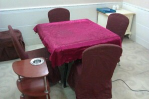 Ein Essbereich mit einem Tisch, der mit einer roten Tischdecke bedeckt ist und von Stühlen umgeben wird.