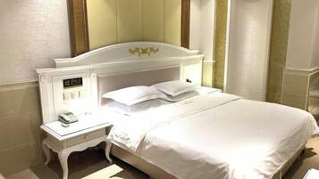 A hotel room with a bed, a bedside table, and a nightstand.