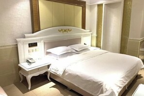 Een hotelkamer met een bed, nachtkastje en een bedtafel.