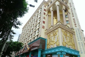 A multi-story hotel with a prominent facade featuring ornate golden lion sculptures.
