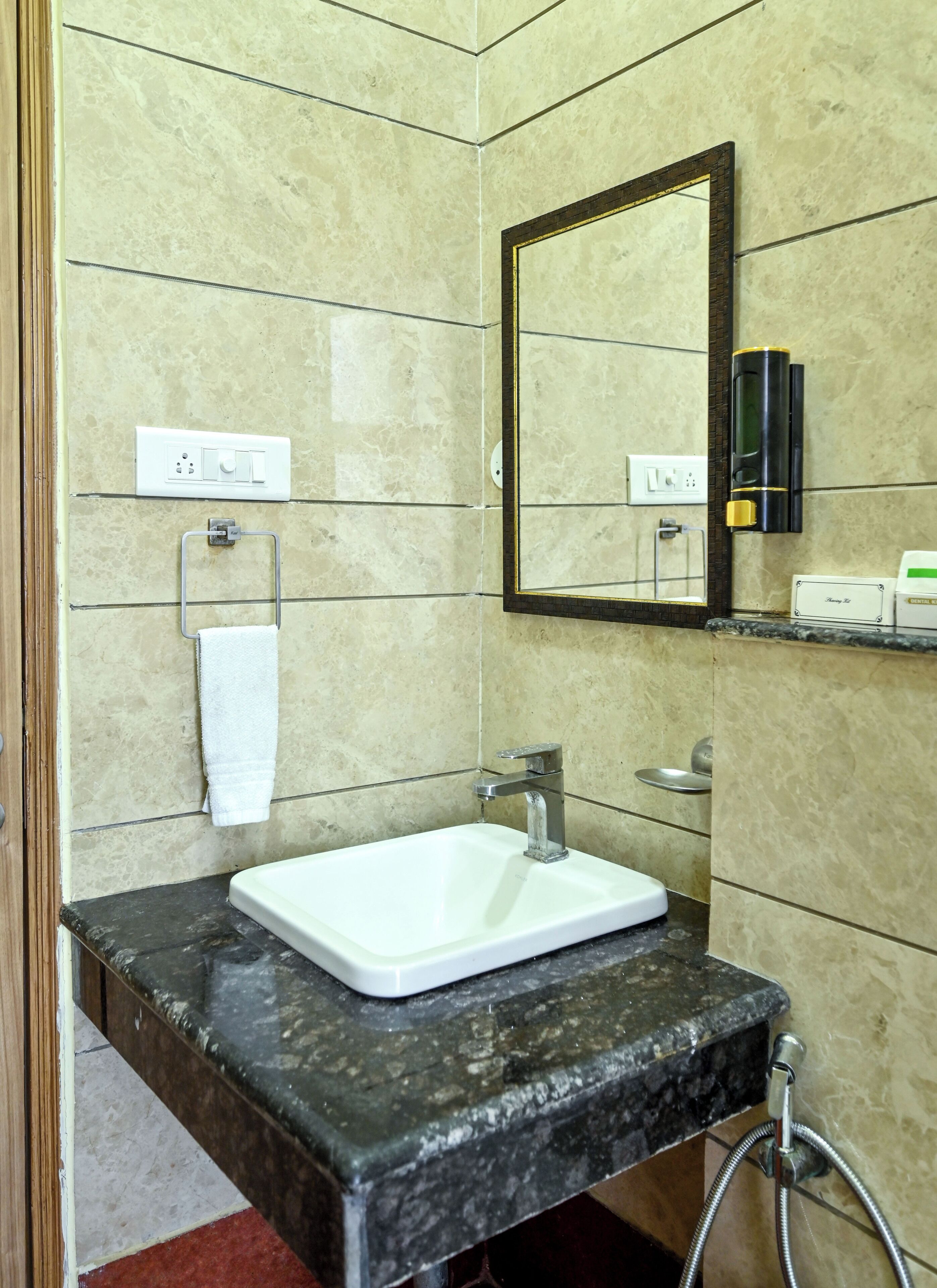 A bathroom with a white sink, a mirror, and a towel rack.