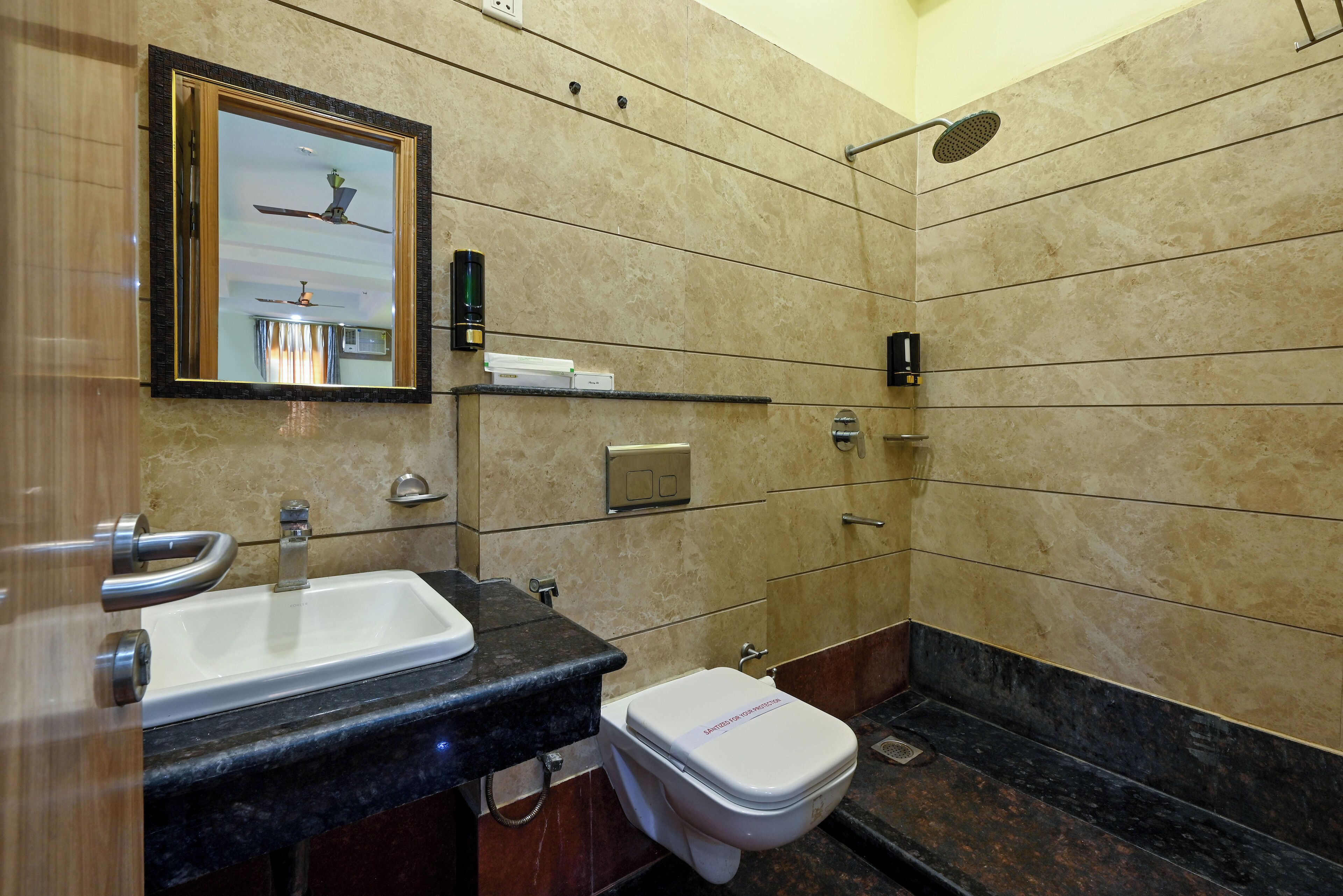 A bathroom with a sink, mirror, toilet, and shower.