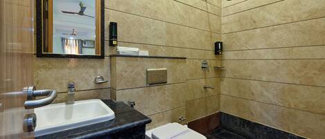 A bathroom with a sink, mirror, toilet, and shower.