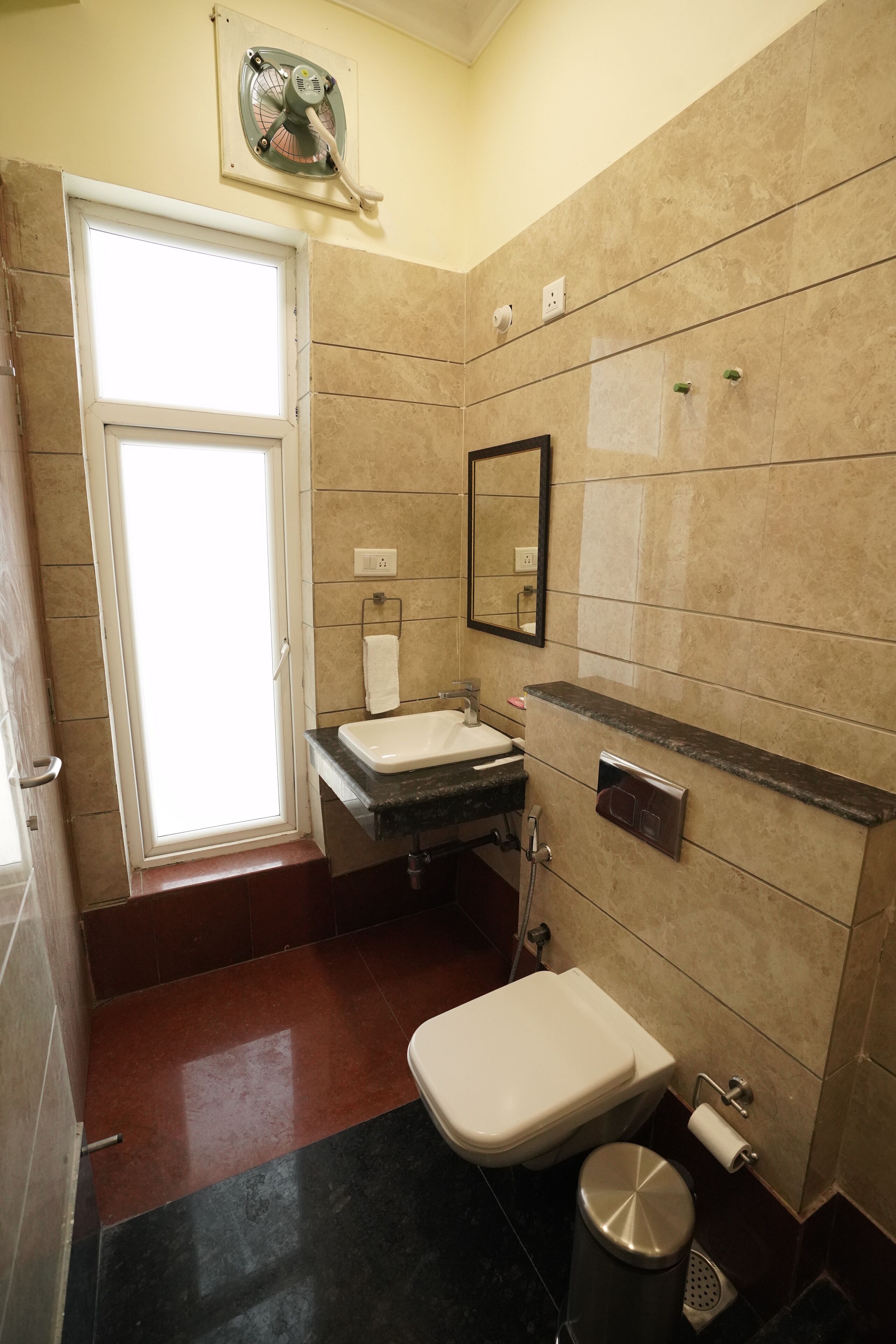 A bathroom with a sink, toilet, and a mirror.