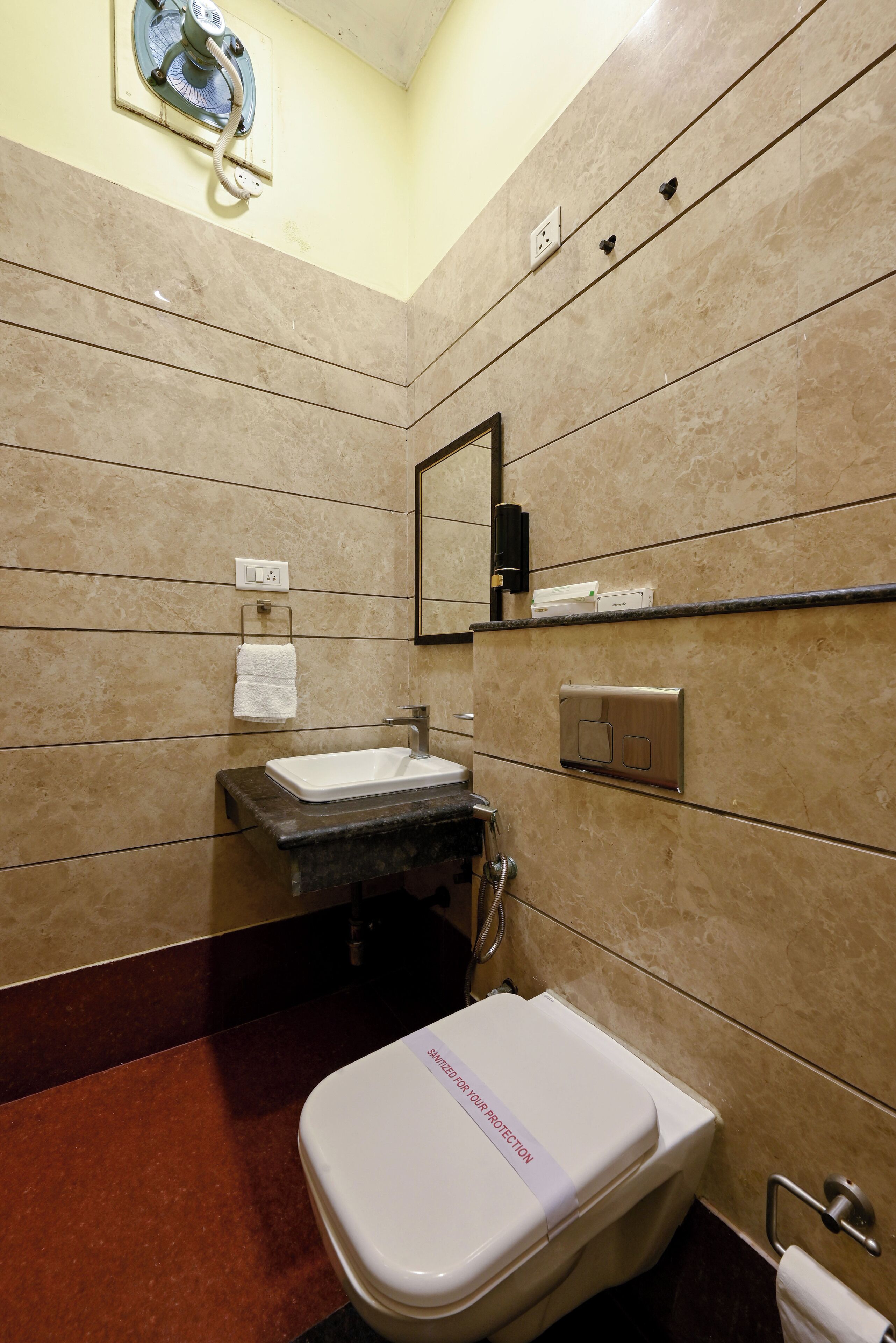 A bathroom with a sink, mirror, and toilet.