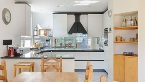 A modern kitchen with a central island, wooden chairs, and a dining table. - Résidence La Vallée Blanche in Chamonix Balcony & Mont Blanc Views, Chamonix, France (Chamonix)