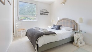 A bedroom with a bed, a chair, a window, and a nightstand. - Résidence La Vallée Blanche in Chamonix Balcony & Mont Blanc Views, Chamonix, France (Chamonix)