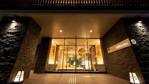 La entrada del Hotel La'gent Kyoto Nijo, con un diseño moderno, presenta un llamativo logotipo GT sobre la entrada.