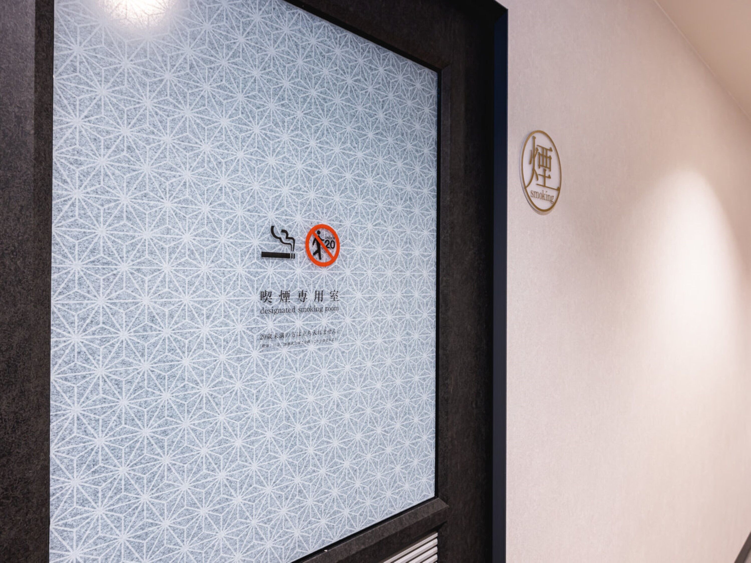 A designated smoking room sign with a no-smoking symbol and Japanese text.