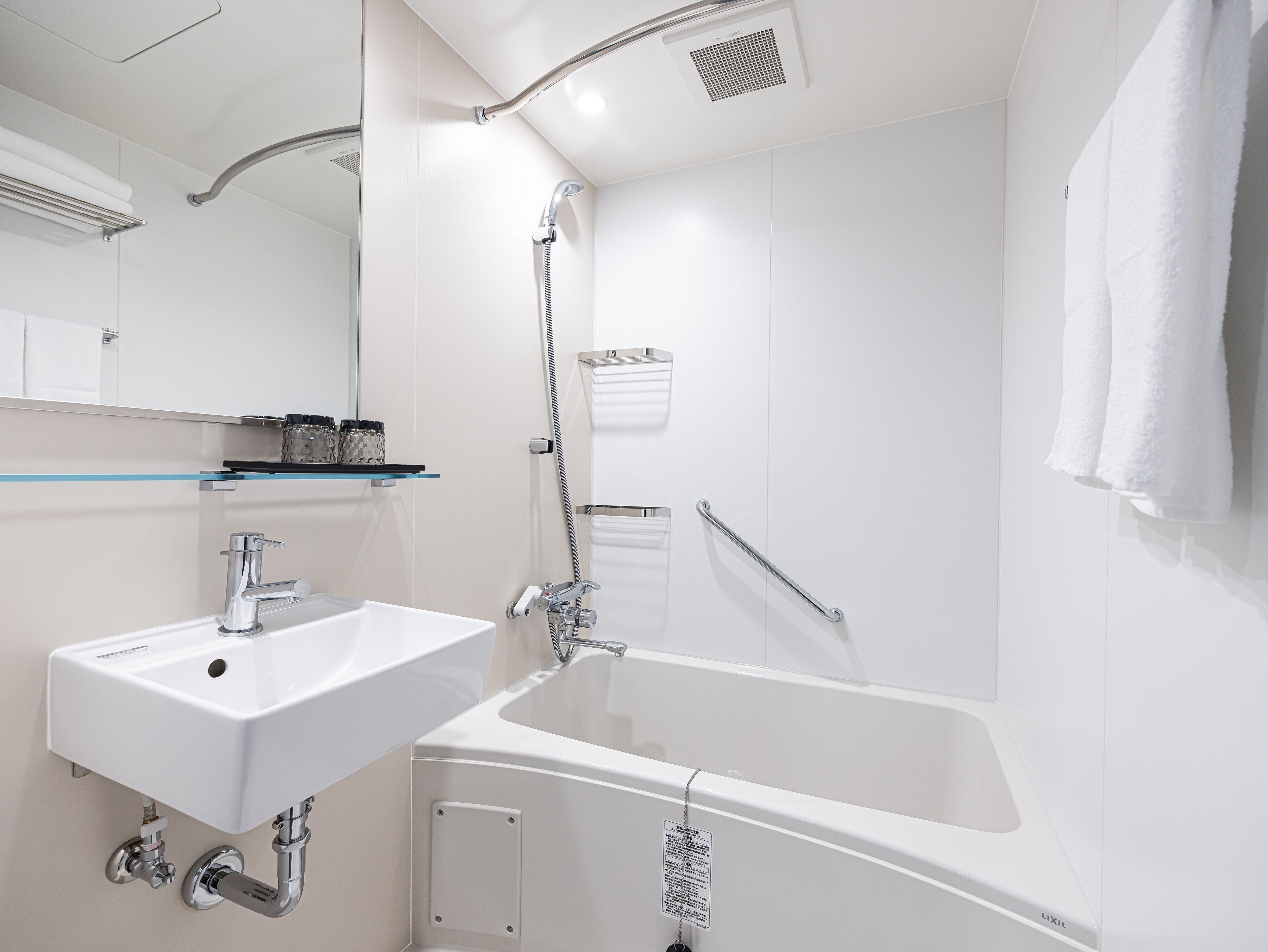Une salle de bain moderne avec un lavabo blanc, une baignoire et une douche.