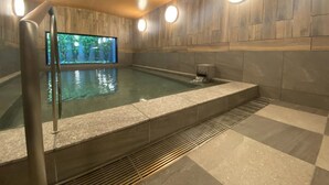 Una piscina interior moderna con una pared de madera y un ventanal grande.