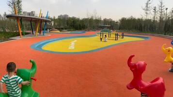 A playground with colorful play equipment and a yellow and orange play surface.