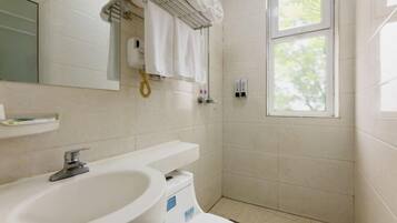 A bathroom with a sink, toilet, and shower.