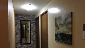 Un corridoio con parete in pietra, porta in legno e un quadro con fiori.