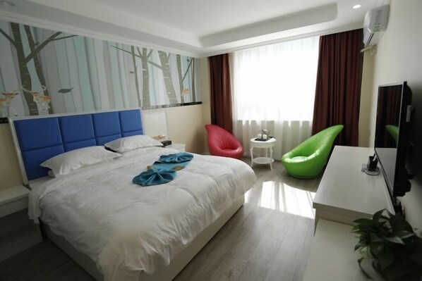 A hotel room with a large bed, a desk, a chair, a TV, and a window with curtains. - Best Holiday Hotel (Foping County)