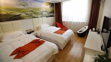 A hotel room with two beds, a desk, a chair, and a large window with curtains.