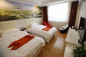 Habitación de hotel con dos camas, un escritorio, una silla y un amplio ventanal con cortinas.
