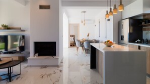 Una cocina moderna con una isla central, electrodomésticos integrados e iluminación colgante.