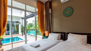 Ein Hotelzimmer mit großem Fenster, einem Bett, einem Nachttisch und Blick auf einen Swimmingpool.