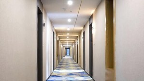 A long, narrow hotel corridor with a patterned carpet, doors on both sides, and a ceiling with recessed lighting. - Xinhuangdu Hotel, Xupu (Lipu)