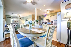 A dining area with a round table, chairs, and a vase of flowers. - Slice of Paradise: Big Pine Key Waterfront | Heated Pool, Dockage & Open-Water Views (Big Pine Key)