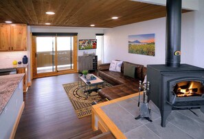 A living room with a fireplace, a sofa, a coffee table, and a television.