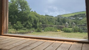 Un rebord de fenêtre en bois, avec une petite table en bois et un cadenas.