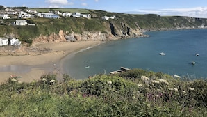 A coastal landscape with houses on a hillside, a sandy beach, and a calm sea. - The Snug - Beautiful Grade 2 listed barn conversion (Mevagissey)