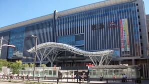 En moderne bygning med en glasfacade og en markant, hvid metalstruktur foran, samt skiltning for en biograf og et tilbud på rabatkort.