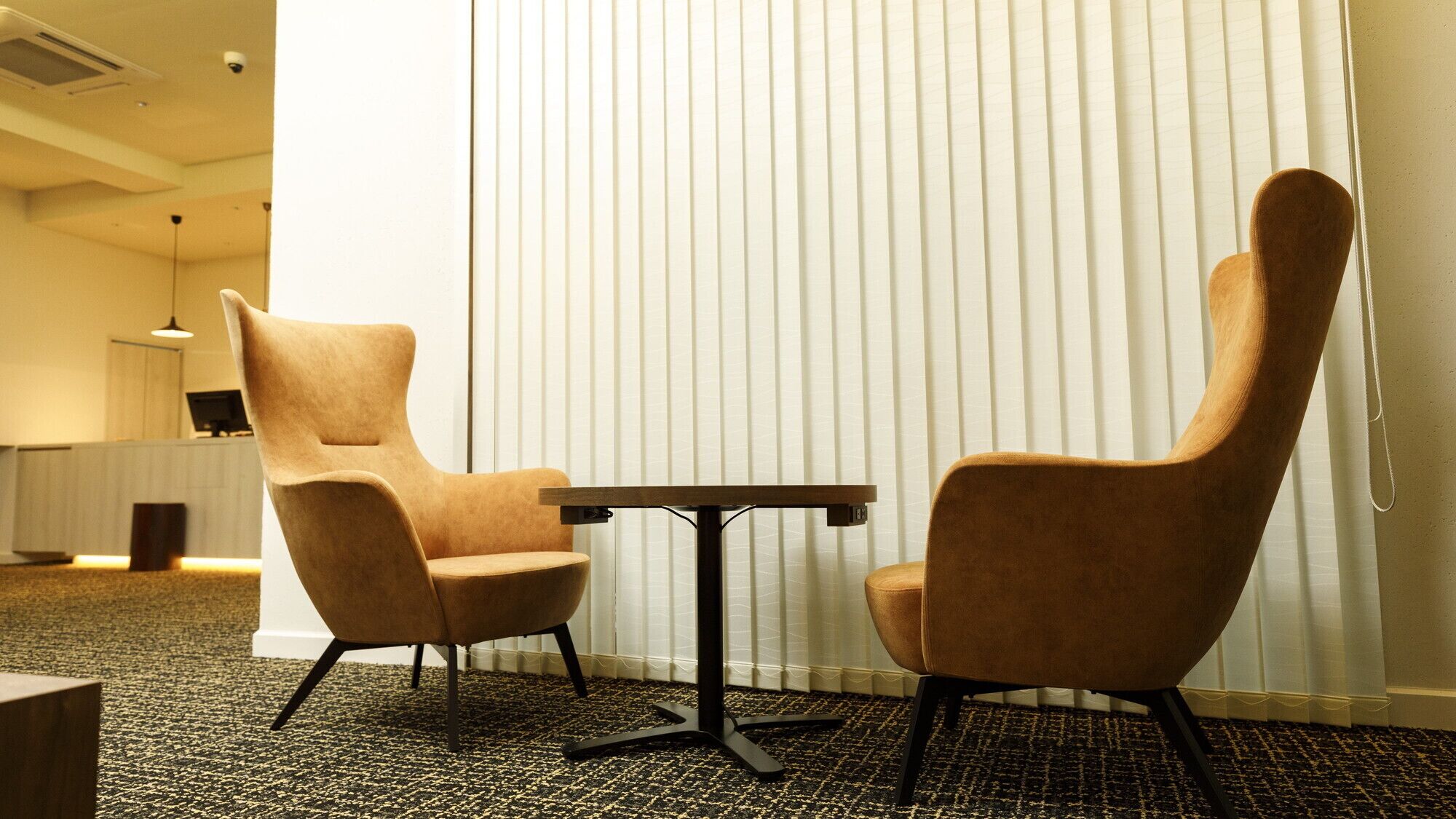 Ein Zimmer mit zwei Stühlen, einem kleinen Tisch und einer Heizung.
