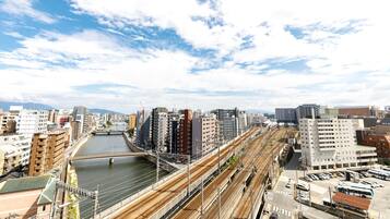 A cityscape with multiple train tracks, buildings, and a river.